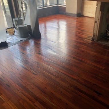 dining room area with glossy brown hardwood flooring with construction going on around it